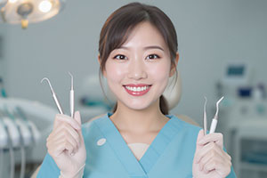 治療器具を持つ歯科衛生士