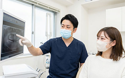 レントゲンを見ながら話す歯科医師